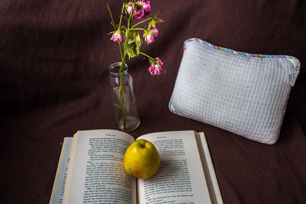 open book with apple and rose