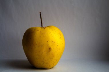 Beyaz arkaplanda sarı elma