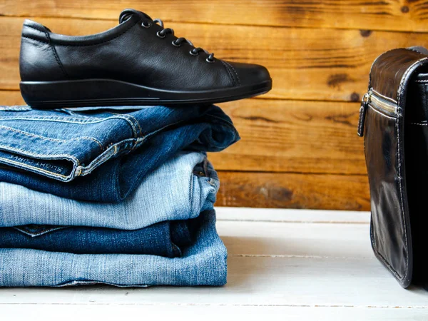 Zapatos en una pila de jeans y bolsa — Foto de Stock