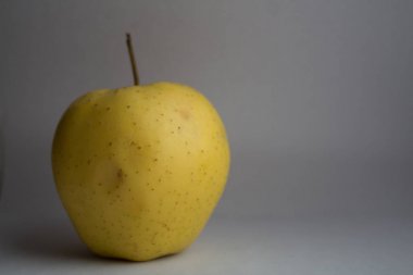 Beyaz arkaplanda sarı elma