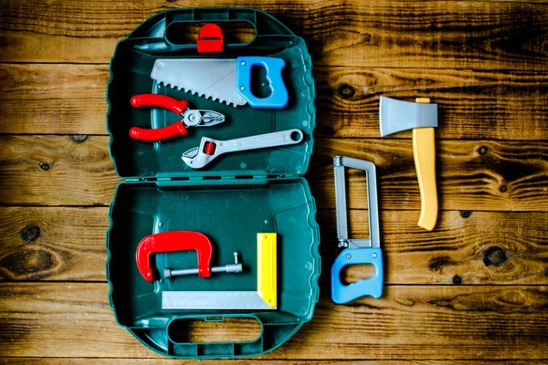 Caja con herramientas para niños sobre fondo de madera —  Fotos de Stock