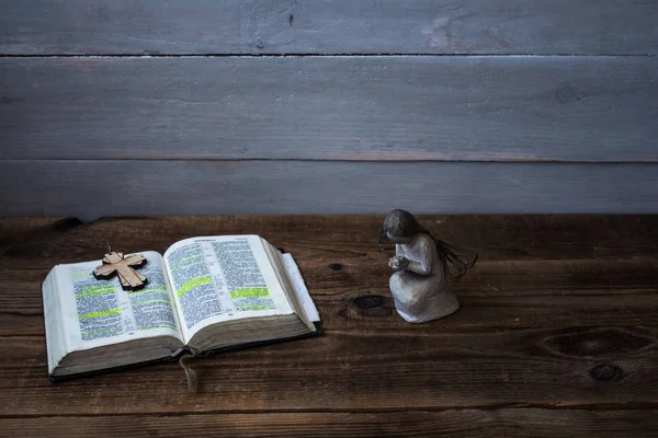 Ein Engel öffnet Bibel und Kreuz — Stockfoto