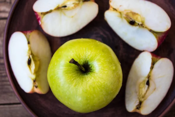 Pomme verte sur une assiette sur fond en bois — Photo