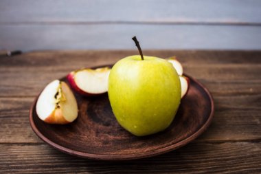 ahşap arka plan üzerinde bir plaka üzerinde yeşil elma