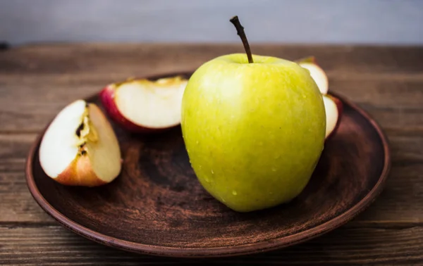 Pomme verte sur une assiette sur fond en bois — Photo