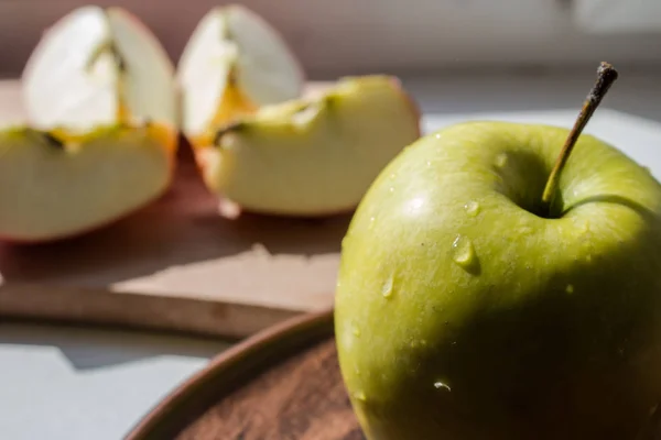 Pomme verte sur une assiette au soleil — Photo