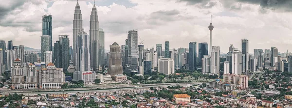 Petronas ikiz kuleleri ve diğer kurumsal binalar ile Kuala Lumpur siluetinin panoramik manzaralı — Stok fotoğraf
