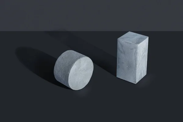 Figuras de concreto simples localizadas em um fundo escuro Fotos De Bancos De Imagens