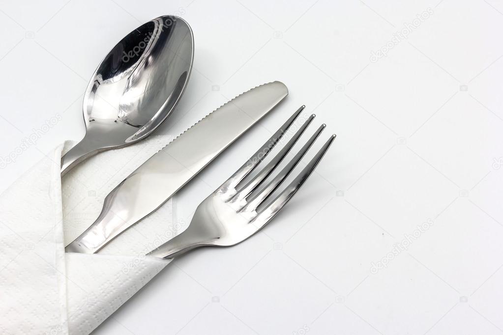 Knife, fork and spoon with serviette, isolated on the white background.