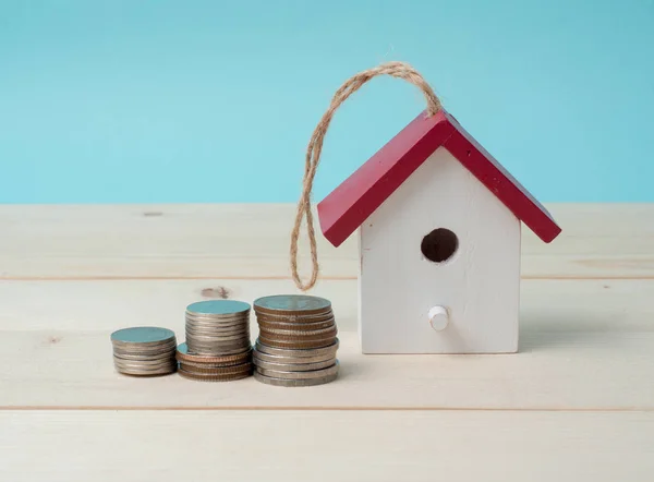 Pila de monedas con modelo de casa, planes de ahorro para la vivienda espalda azul — Foto de Stock