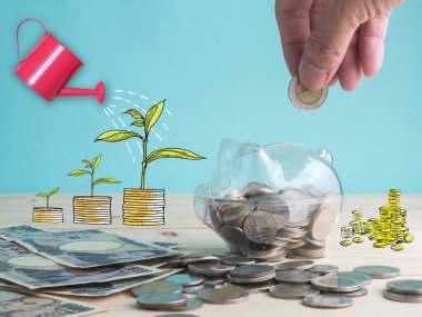 piggy banka aracılığıyla şeffaf bkz: sikkeleri üzerinde tahta arka plan ile dolu. Yatırım renkli kavramı kaydetme.