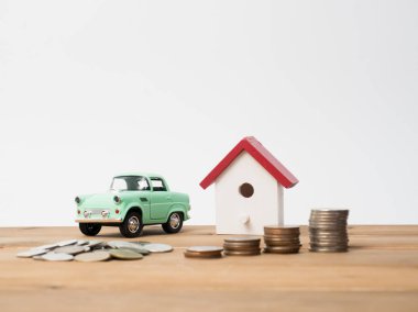 Kırmızı house ile ahşap arka plan üzerinde büyüyen para sikke yığını.