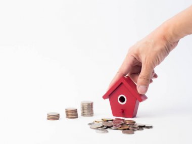 Kırmızı house ile ahşap arka plan üzerinde büyüyen para sikke yığını