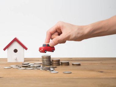 Kırmızı house ile ahşap arka plan üzerinde büyüyen para sikke yığını.