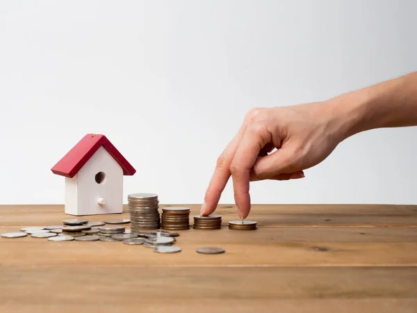 Monedas de dinero pila creciendo con casa roja sobre fondo de madera — Foto de Stock