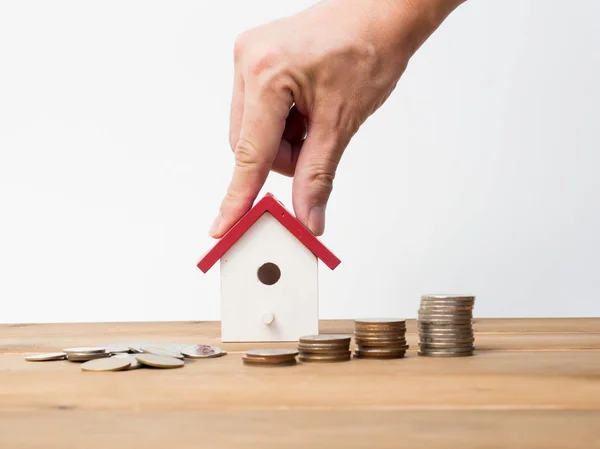 Monedas de dinero pila creciendo con casa roja sobre fondo de madera — Foto de Stock