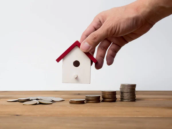 Monedas de dinero pila creciendo con casa roja sobre fondo de madera . — Foto de Stock