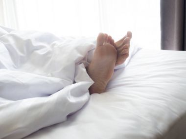Uyuyan kadın yatakta yatan genç bir kadın beyaz yatak room.feet metrelik yakın çekim.