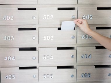 Birinin elini close-up. el bir mektubu posta kutusuna bir apartman binası giriş holü kaldırma