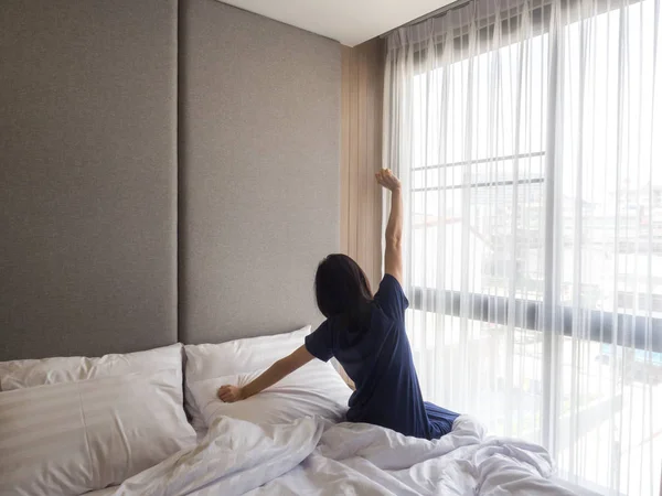 Nő nyújtás az ágyban, ébredés után, hátsó nézet — Stock Fotó