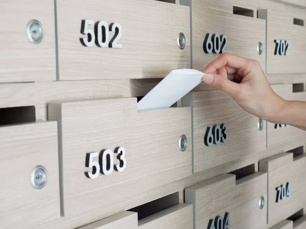 Birinin elini close-up. el bir mektubu posta kutusuna bir apartman binası giriş holü kaldırma