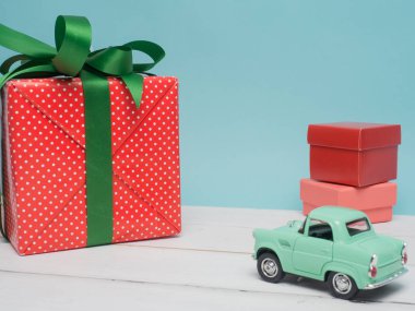 Eski model araba Noel ve yeni yıl ve Sevgililer günü için bir hediye kutusu renk arka plan ve üst ahşap masa üzerinde taşırlar. Dekorasyon aşk kalp .