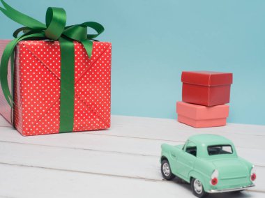 Eski model araba Noel ve yeni yıl ve Sevgililer günü için bir hediye kutusu renk arka plan ve üst ahşap masa üzerinde taşırlar. Dekorasyon aşk kalp .