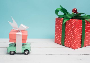 Eski model araba Noel ve yeni yıl ve Sevgililer günü için bir hediye kutusu renk arka plan ve üst ahşap masa üzerinde taşırlar. Dekorasyon aşk kalp .