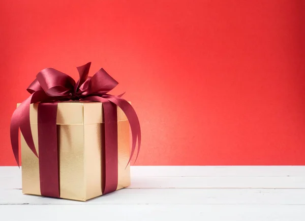 Valentinstag, Neujahr goldene Geschenkbox mit roter Schleife. rot — Stockfoto