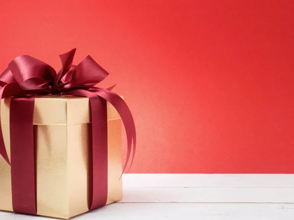 Festival de San Valentín, Año Nuevo Caja de regalo de oro con cinta roja. Rojo. —  Fotos de Stock