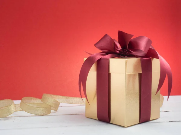 Festival de San Valentín, Año Nuevo Caja de regalo de oro con cinta roja. Rojo. —  Fotos de Stock