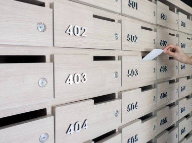 Birinin elini close-up. el bir mektubu posta kutusuna bir apartman binası giriş holü kaldırma