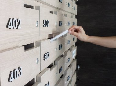 Birinin elini close-up. el bir mektubu posta kutusuna bir apartman binası giriş holü kaldırma