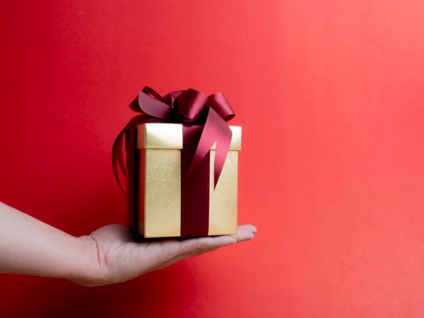 Festival de San Valentín, Año Nuevo Caja de regalo de oro con cinta roja. Rojo. —  Fotos de Stock