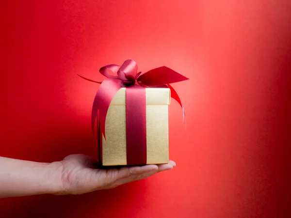 Festival de San Valentín, Año Nuevo Caja de regalo de oro con cinta roja. Rojo. —  Fotos de Stock