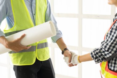 İş insanlar el sıkışma close-up. Ofis Merkezi tokalaşırken yakışıklı inşaat işçisi