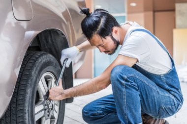 Otomobil tamir garajda araba motoru tamir. Yakışıklı makinist