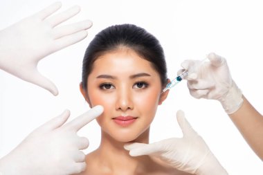 Asyalı genç bir kadın dudaklarına iğne oluyor. Güzellik içinde bir kadın