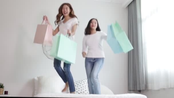 Happy Two Asian Young Woman Soring Jumping Bed Holding Color — Vídeo de Stock