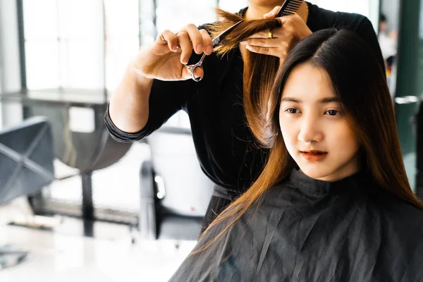 若いアジアの美しい女性は 美容師ので彼女の髪をカットしています はさみは 女の子の髪をカットします — ストック写真