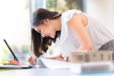 Mimar ya da iç mimar galeride malzeme numune tahtasıyla çalışıyor. Emlak işi, ev dekorasyonu. Yaratıcı insanların çalıştığı yer. Ofis masasında renk paletiyle çalışan genç tasarımcı kadın..