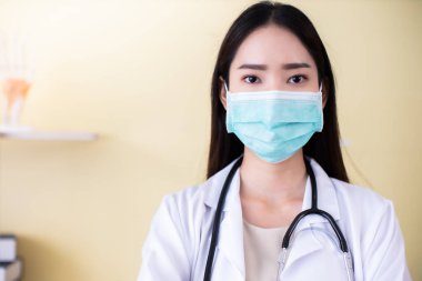 Tıp ve sağlık hizmetleri kavramı. Hastanede yatan Asyalı doktor kadın. Doktor ya da hemşire koruma maskesi takıyor. Enfeksiyonluları kontrol ve tedavi ediyor. .