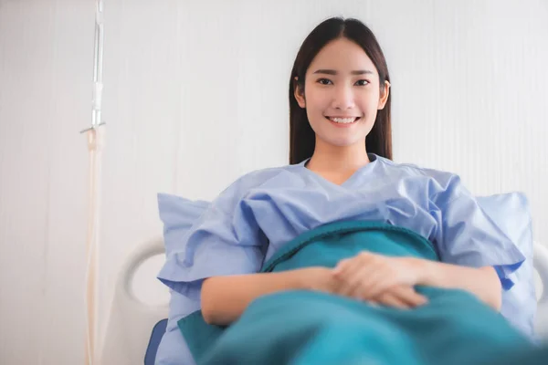 Asyalı hasta kadınlar ve hastane konsepti - Asyalı hasta kadınlar yataklarında tek başlarına hastane odalarının pencerelerini görüyorlar