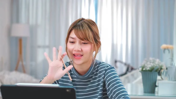 Online Group Video Call Conference of Work Team from Home Office.Smiling young asian woman blogger vlogger influencer sit at home speaking.online with internet teacher learn language talk .young woman make video call tutoring