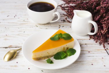 Cheesecake, kahve, süt kavanoz ve heather çiçekler