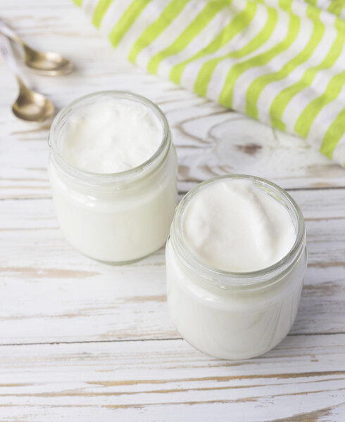 Домашний йогурт в стеклянной банке на деревянном столе
. 