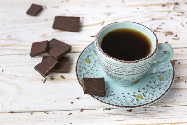 Tasse Kaffee, dunkle Schokolade auf Holztisch — Stockfoto