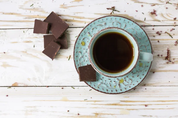 Kopje koffie, donkere chocolade op houten tafel — Stockfoto