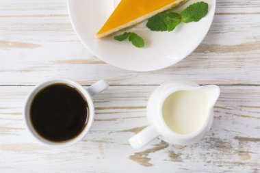 Cheesecake, kahve ve süt kavanozu fincan