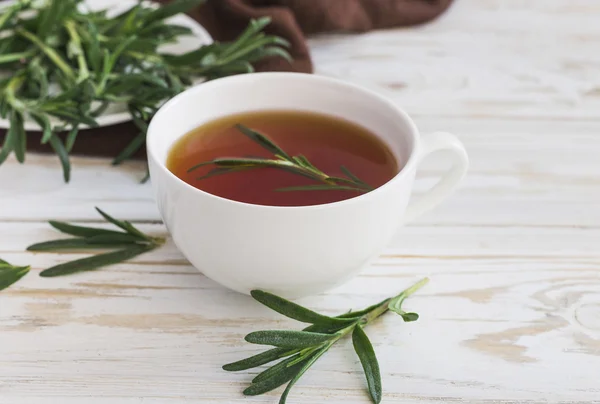 Pot de thé et de lait au romarin sur table en bois . — Photo